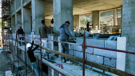 Arab-construction-workers-stand-on-scaffolding