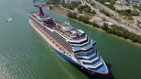 Drone-circling-a-cruiseliner-leaving-the-port-of-Miami,-sunny-day-in-Florida,-USA