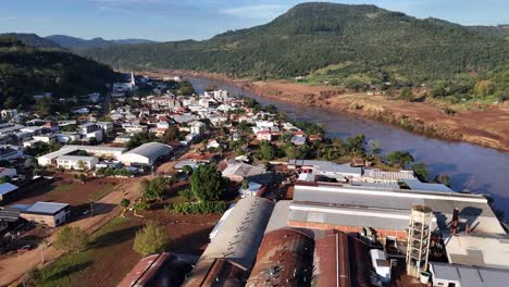 City-businesses-river-location-threatened-by-rising-rainfall,-aerial