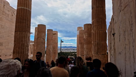 Gente-Abarrotada-Caminando-A-Través-De-Los-Pilares-Del-Monumento-Agripa-En-La-Acrópolis-De-Atenas,-Grecia