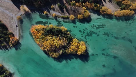 Colourful-Autumn-scene-of-tree-island-in-pristine-lake