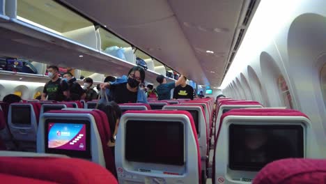 Chinese-people-placing-hand-luggage-inside-aircraft-cabin-in-Beijing-airport-during-Covid-19-pandemic