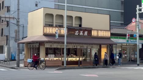 Traffic-passing-in-front-of-a-restaurant-on-the-corner-of-a-street-in-Kyoto-Japan