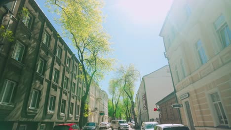 Float-and-fly-through-Daugavpils-street-during-sunny-spring-with-traffic-and-architecture