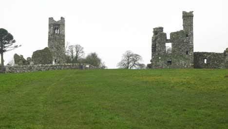 Historic-ruins-of-St-Erc's-church-and-college-on-the-Hill-of-Slane,-Ireland,-with-lush-green-field-in-foreground