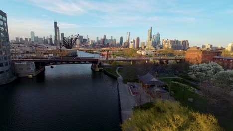 Vista-Aérea-Por-Drones-De-La-Hora-Dorada-Vista-Serena-Del-Paisaje-Urbano-De-Chicago,-Donde-La-Arquitectura-Se-Alza-Junto-A-Un-Río-Tranquilo,-Que-Encapsula-La-Combinación-Armoniosa-De-Vida-Urbana-Y-Belleza-Natural.