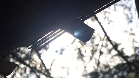 Slow-motion-shot-of-the-sunlight-revealing-from-beneath-a-pergola