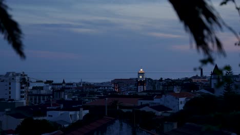 Zoom-in-over-Ponta-Delgada-cityscape-with-Historic-Church-of-São-Sebastião,-Day-to-Night-Time-Lapse