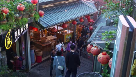 People-walking-up-the-stairs-to-taste-famous-freshly-made-A-Gan-Yi's-Taro-balls-dessert-at-Jiufen's-old-street-in-the-charming-mountain-village-town-with-red-lanterns-hanging-along-the-way