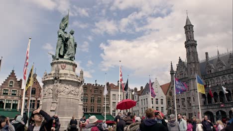 Statue-of-Jan-Breydel-and-Pieter-de-Coninck-At-Crowded-Market-Square-In-Bruges,-Belgium