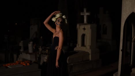 A-woman-dressed-like-Catrina-or-skull-lady-modeling-in-a-Mexican-graveyard