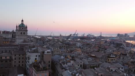 Genoa's-historical-center-at-sunset-with-a-skyline-of-cranes-and-the-sea,-aerial-view