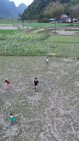 Cao-Bang,-Vietnam---Children-Playing-in-Fields,-vertical-aerial-view