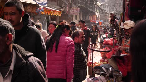 People-walking-through-a-busy-market-in-a-town-square,-Bhaktapur,-Kathmandu-Valley,-Nepal