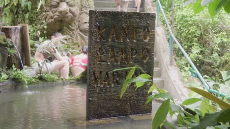 A-sign-with-the-inscription-"Kanto-Lampo"-stands-at-the-entrance-to-the-Kanto-Lampo-waterfall-in-Bali,-Indonesia