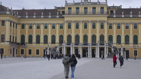 Schönbrunn-Palace-in-Vienna-during-a-cold,-cloudy-afternoon,-with-tourists-wandering-around-the-grounds