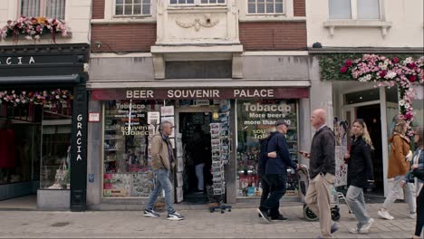 People-Walking-On-Street,-Passing-By-In-Front-Of-Souvenir-Shop-In-Bruges,-Belgium