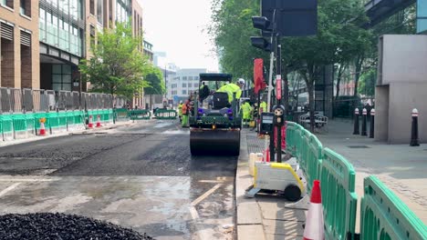 Trabajador-De-La-Construcción-Conduciendo-Apisonadora-Compactando-Asfalto-Fresco-En-Queen-Victoria-Street-En-El-Centro-De-Londres