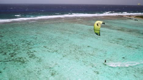 Un-Kitesurfista-En-Aguas-Turquesas-Cerca-Del-Arrecife-De-Coral,-Los-Roques,-Vista-Aérea