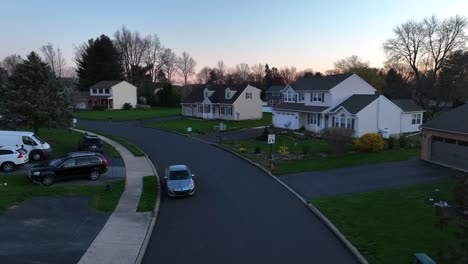 Conducir-Un-Coche-En-La-Calle-De-Una-Tranquila-Zona-Residencial-Americana-En-La-Hora-Dorada