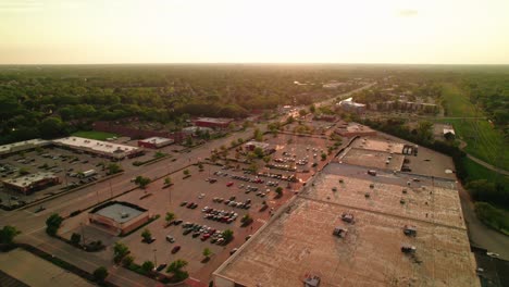 Aerial-of-a-bustling-highway-adjacent-to-Arlington-Heights'-shopping-mall-center,-illustrating-the-synergy-of-urban-connection-and-bustling-commerce-in-Illinois,-USA