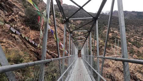 Überqueren-Einer-Metallwanderbrücke-Mit-Buddhistischen-Gebetsfahnen