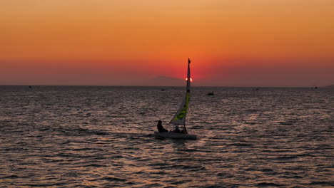 Velero-Auxiliar-Para-3-Personas-Al-Atardecer-Navegando-Por-Un-Cielo-Ardiente