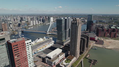 De-Rotterdam-And-New-Orleans-Buildings-With-Erasmusbrug-Bridge-In-Rotterdam,-Netherlands---Drone-Shot