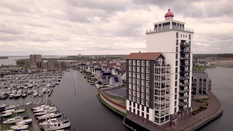 Antena-Del-Puerto-Recreativo-De-Knar-En-Veluwemeer-Con-Embarcaciones-De-Recreo-Y-Edificio-De-Apartamentos-En-Forma-De-Faro.