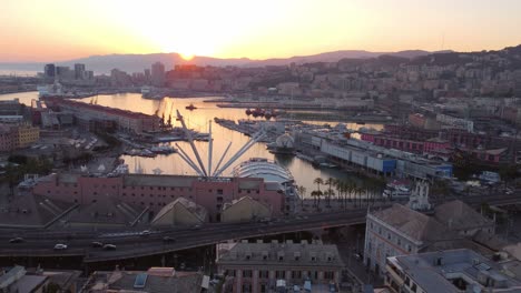 Genoa's-historical-center-and-port-at-sunset,-showcasing-the-vibrant-harbor-and-cityscape,-aerial-view