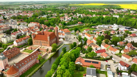 Castillo-Con-Torre,-Río-Y-Campo-De-Canola-En-La-Pequeña-Ciudad-Polaca-De-Lidzbark-Warminski.