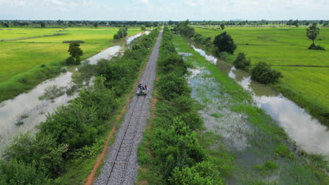 Bamboo-Railway-Car-Travels-Along-The-Line-On-A-Cloudy-Day-Drone-Tracking-From-Front