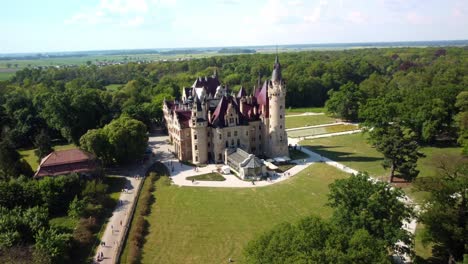 Old-Polish-Castle-In-The-Village-Of-Moszna,-Poland---Aerial-Drone-Shot