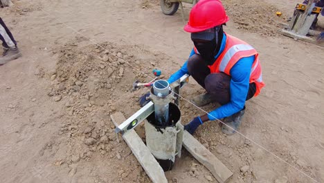 Construction-worker-in-safety-gear-operating-equipment-at-a-dusty-outdoor-site,-close-up