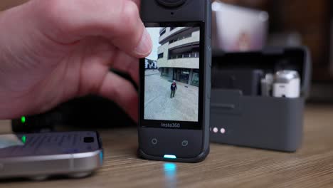 Close-up-of-hand-viewing-and-turning-a-360-degree-video-on-Insta360-action-camera