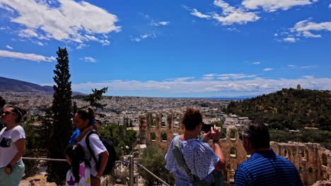 Gente-Haciendo-Turismo-Con-El-Odeón-De-Herodes-Atticus-Al-Fondo-En-Atenas,-Grecia
