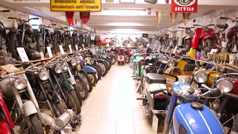 First-person-POV-walking-down-row-of-vintage-motorcycles-on-display-in-museum
