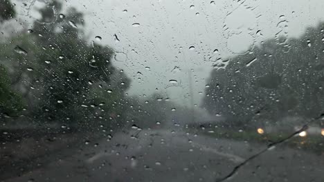 Pov-De-Lluvia-Cayendo-Sobre-El-Parabrisas-De-Un-Automóvil-Mientras-Conduce-En-Hong-Kong