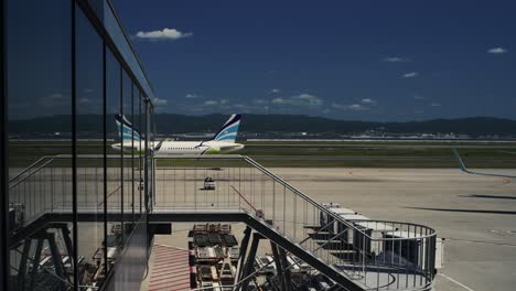 Air-Busan-Flugzeug-Auf-Der-Landebahn-Spiegelt-Sich-Im-Glas-Des-Terminals