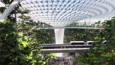 Vista-Panorámica-De-La-Cascada-Del-Aeropuerto-Jewel-Changi-En-Singapur-Con-Sky-Train