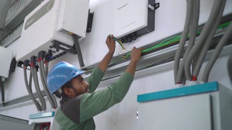 Profile-view-of-a-mechanic-fixing-electric-wires-of-solar-inverters-in-textile-industry-of-Pakistan