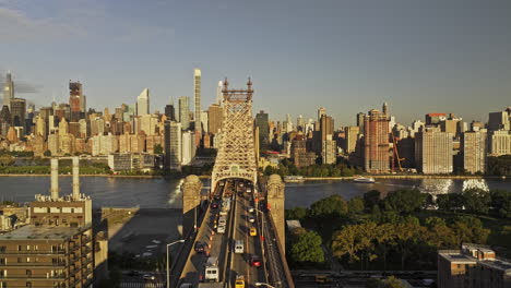 NYC-New-York-Luftaufnahme-V385-Überführung-über-Die-Queensboro-Bridge-über-Den-East-River-Mit-Blick-Auf-Die-Stadtlandschaft-Von-Midtown-Manhattan,-Wobei-Die-Morgensonne-Die-Fassaden-Der-Stadt-Küsste-–-Aufgenommen-Mit-Mavic-3-Pro-Cine-–-September-2023