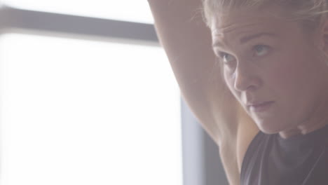 Focused-facial-expression-on-woman-as-she-does-clean-and-jerk-weightlifting-move