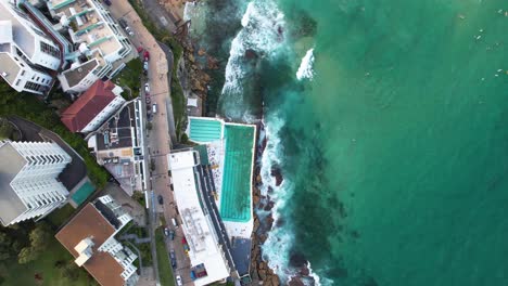 A-birds-eye-drone-view-looking-down-on-the-Bondi-Icebergs-Club-on-Bondi-Beach-in-Sydney,-New-South-Wales