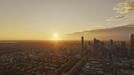 NYC-New-York-Luftaufnahme-V369-Überführung-über-Den-East-River-Und-Die-Queensboro-Bridge,-Die-Das-Stadtbild-Von-Long-Island-City-In-Queens-Und-Die-Leuchtende-Sonne-Am-Horizont-Einfängt-–-Aufgenommen-Mit-Mavic-3-Pro-Cine-–-September-2023