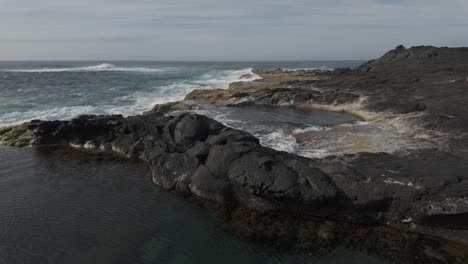 Rugged-volcanic-coastline-with-natural-pools-in-Mosteiros,-Azores,-Sao-Miguel,-under-cloudy-skies