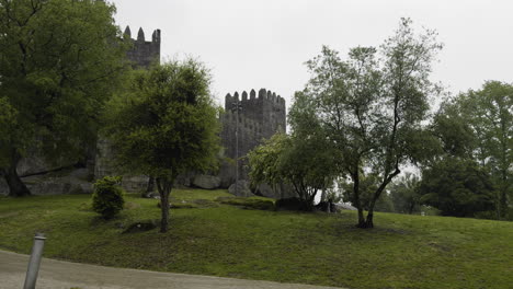 Pan-down-from-castle-walls-and-green-ground-on-rainy-day-in-Portugal