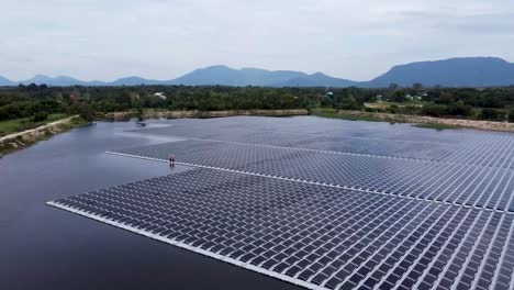 Vista-Aérea-De-Un-Enorme-Panel-Solar-Sobre-El-Agua-En-Una-Zona-Rural,-Granja-Solar-Flotante