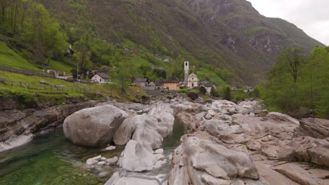 Antena-Estableciendo-Dolly-A-La-Capilla-En-El-Valle-De-Verzasca-Lavertezzo-De-Suiza,-Líneas-Principales-Desde-Arroyos