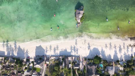 Drohne-Von-Oben-über-Haus-Und-Palmenschatten-Am-Türkisfarbenen-Strand-Im-Sonnenuntergang